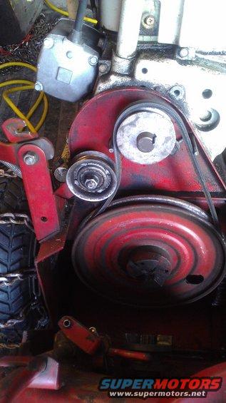 Red engine component with drive belt, pulleys, and a tire with chains