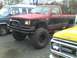 1987 Mazda RX-7 - A modified pickup truck with large off-road tires is parked outdoors.