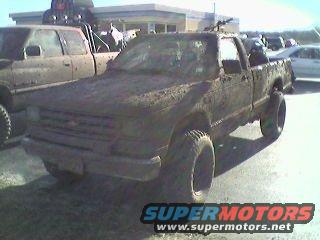 Mud-covered pickup truck with lifted suspension