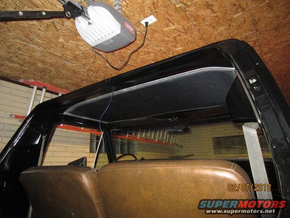 1979 Ford Bronco interior showing brown seats and black headliner. Garage door opener visible on ceiling