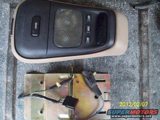 Overhead console light and control panel with buttons labeled GARAGE, LAMP, MODE, LAMP, and a separate metal bracket with wiring