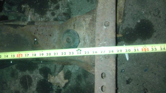Front suspension part with measuring tape showing 13-34 inches