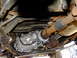 1995 Ford Bronco - Underside view of a vehicle's transfer case and driveshaft, showing mechanical components.