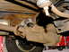 1995 Ford Bronco - Underside view of a heavily rusted rear differential and driveshaft components.