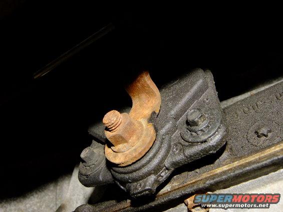 Rusted metal bracket with bolt and nut, close-up view