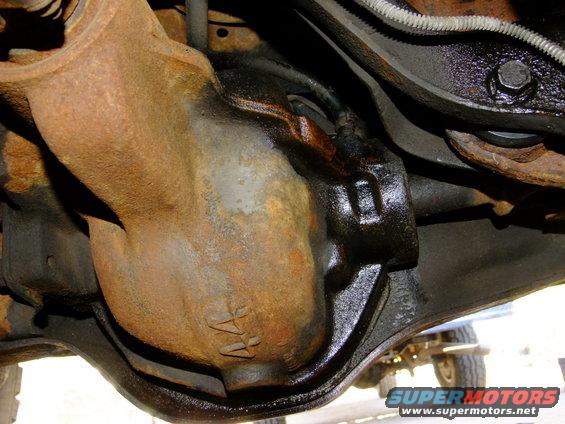 Close-up of a rusty rear differential housing with some oil leakage