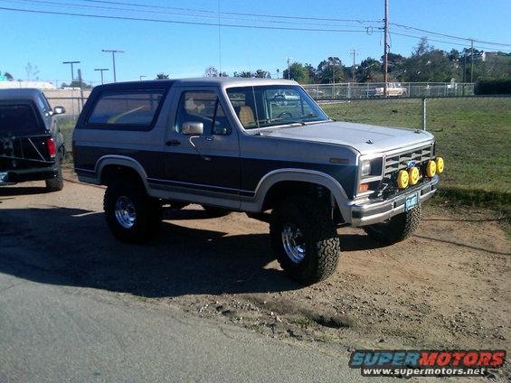 Two-tone gray and green lifted Ford Bronco with yellow fog lights and off-road tires