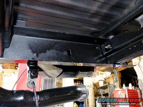 Black painted vehicle chassis with visible frame rails and exhaust pipe