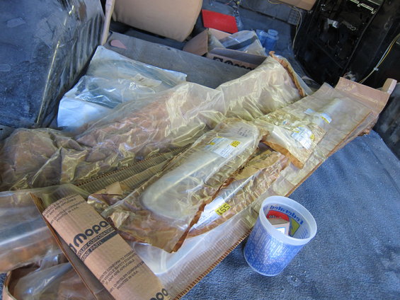 Mopar parts in plastic packaging, including a chrome trim piece and a roll of paper