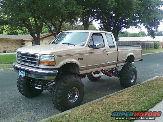 Lifted tan pickup truck, 3q-front view. Grille indicates 1992 model year
