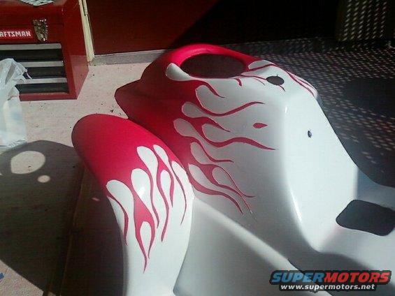 White and red motorcycle fairing with flame graphics. Craftsman toolbox in background
