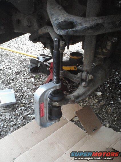 Ball joint separator tool on vehicle suspension component