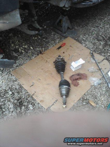 CV axle on cardboard with tools