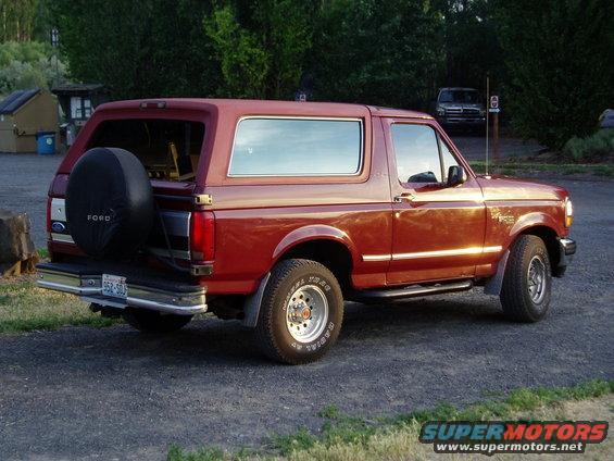 1993 Ford Bronco parked outside, spare tire on rear door. Another vehicle is visible in the background