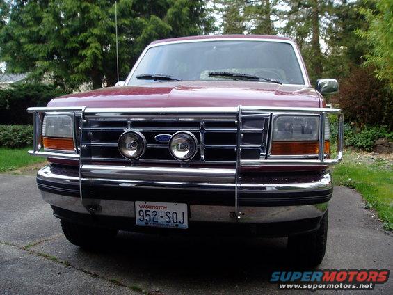 Maroon Ford Bronco with chrome bull bar and fog lights. Front view
