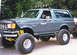 1988 Ford Bronco - This modified 1988 Ford Bronco features a significant lift kit, large off-road tires, and a light bar mounted on the roof.