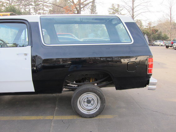 Side view of a black and white Dodge Ramcharger SUV, missing rear bumper