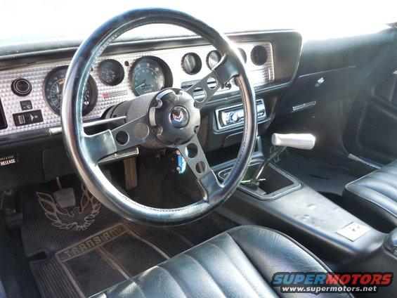Interior view of a 1977 Pontiac Trans Am with a bird logo on the floor mat