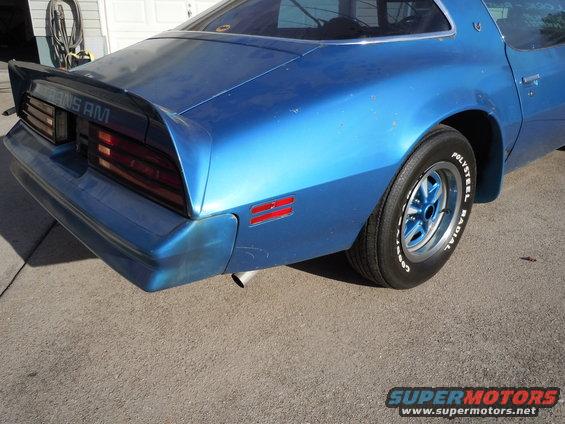 Rear quarter view of a blue Pontiac Trans Am with a spoiler and 'TRANS AM' badging