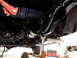1995 Ford Bronco - The underside of a vehicle is shown, supported by jack stands, with a red toolbox nearby.