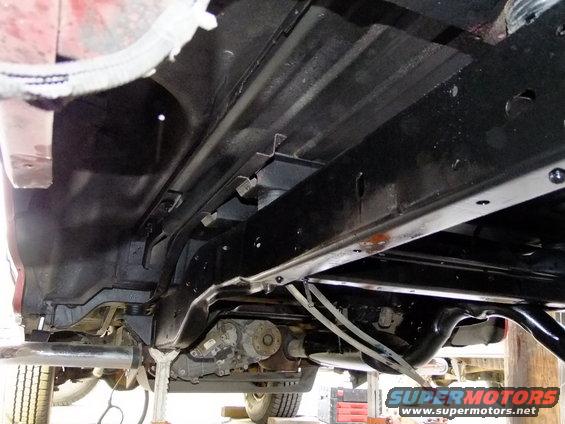 Underside view of a vehicle's chassis, showing the drivetrain and suspension components