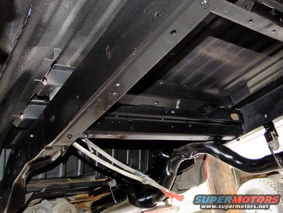 Undercarriage of a vehicle with black painted frame rails and suspension components