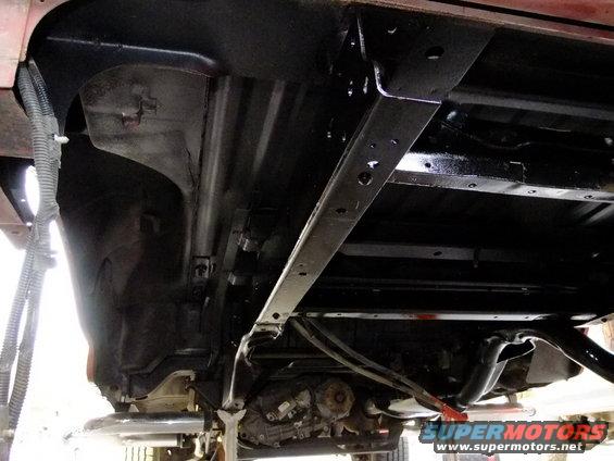 Underside view of vehicle chassis with visible drivetrain components and exhaust