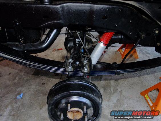 Rear axle assembly with leaf springs and red-booted shock absorber