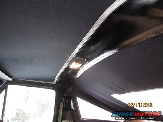 Interior view of a vehicle's headliner and dome light, with a date stamp and website URL
