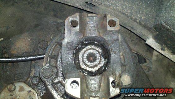 Close-up of a driveshaft flange with a U-joint attached, showing grease and bolts
