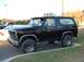 1985 Ford Bronco - This black 1985 Ford Bronco features off-road tires and auxiliary lights mounted on the roof rack.