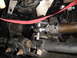 1995 Ford Bronco - Undercarriage view of a vehicle's steering and suspension system, with visible metal components and a red strap.