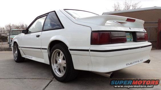 White 1989 Ford Mustang GT coupe with a rear spoiler and aftermarket wheels