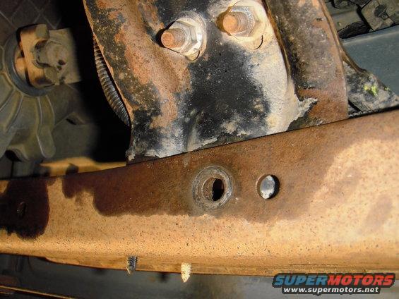 The best locate, the 2 holes you can see are factory. The foward hole you can see was used for the rear hole in the bracket. I drilled the crossmember and just moved the bolt foward for the crossmember and bracket.