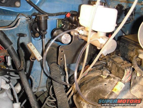 Brake master cylinder reservoir and engine oil dipstick in a vehicle engine bay