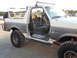 1991 Ford Bronco - This modified Ford Bronco features an open driver's door, revealing its interior and roll cage.