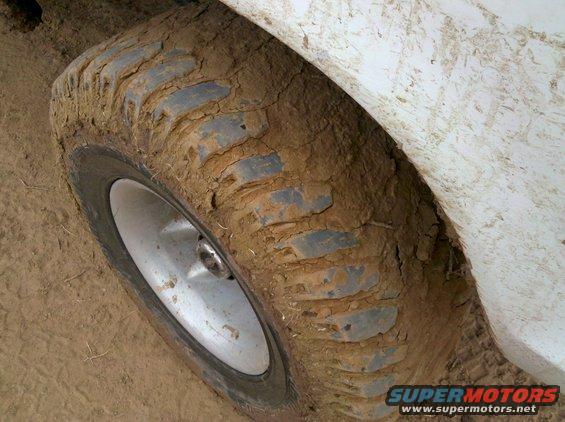 Mud-caked tire and fender of an off-road vehicle
