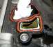 1999 Ford Crown Victoria - Close-up of an engine intake manifold gasket, showing the orange seal and an opening stuffed with a paper towel.