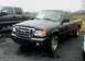 2011 Ford Ranger - A gray Ford Ranger pickup truck is parked on a wet asphalt lot next to another truck.