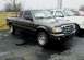 2011 Ford Ranger - A dark gray Ford Ranger pickup truck is parked outside, with other vehicles visible in the background.
