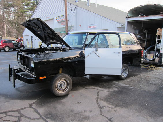 1981 Dodge Ramcharger with hood and driver door open, parked outside a building