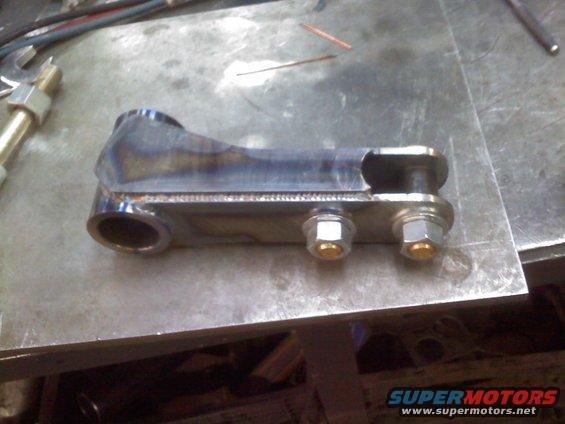 Welded steel suspension part with two bolts on a metal workbench