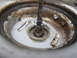1987 Polaris Indy 600 - A close-up view of a corroded metal component with a crudely attached wire, showing signs of wear and tear.