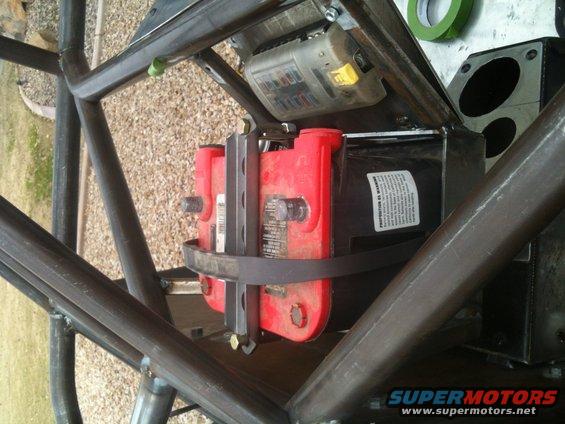 Red Optima battery and fuse box secured within a metal roll cage
