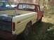 1993 Ford Bronco - A red and white Ford F-Series pickup truck sits in a grassy yard with fallen leaves.