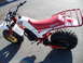 1994 Jeep Cherokee - A Yamaha 200 three-wheeler with a red seat and cargo rack is parked on asphalt.