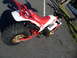 1994 Jeep Cherokee - A red and white Yamaha three-wheeler is parked on asphalt, gold rims and a prominent exhaust pipe.