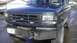 1995 Ford Bronco - Front view of a 1995 Ford Bronco a dark green exterior, custom bumper, and blue lights integrated into the grille.