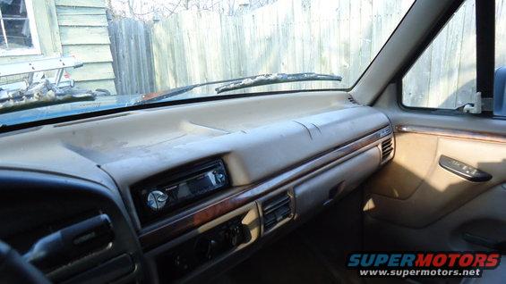 dashboard and center console of a truck with an aftermarket stereo and wood trim