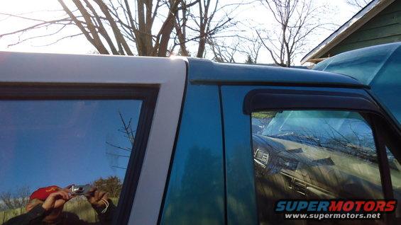 1996 Ford Bronco, teal and white, side view, showing a reflection of a person taking a photo